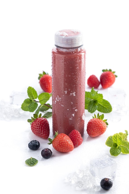 Erdbeer-Smoothie-Flasche mit Detox-Superfood auf weißem Hintergrund und Kopierraum. Hochformat. Konzept für gesunde Getränke.
