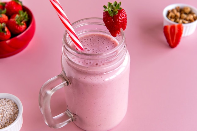 Erdbeer-Smoothie gesunder Shake mit Erdbeere und Milch auf rosa Hintergrund