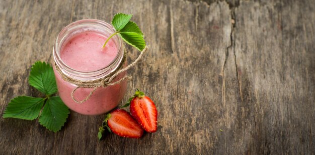 Erdbeer-Smoothies im Glas auf Holzhintergrund. Ansicht von oben. Platz kopieren