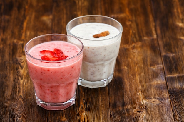 Erdbeer- und Mandelmilch Smoothies in einem Glas, Holztisch