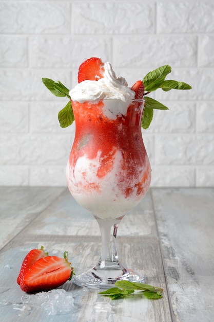 Erdbeerdessert mit Schlagsahne und Minze in einer Glasschale