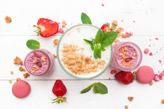 Erdbeere mit Jogurt auf weißer rustikaler Holzoberfläche, Sahnenachtisch