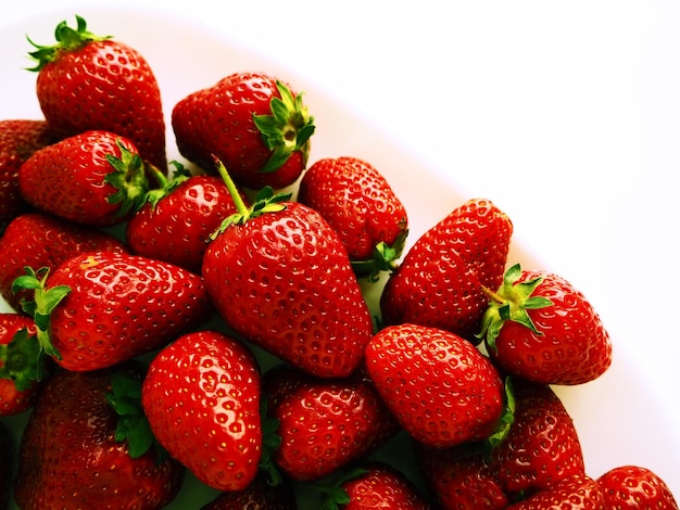 Erdbeeren auf einem Teller Weißer Hintergrund Weiße Gerichte und köstliche rote große Gartenerdbeeren