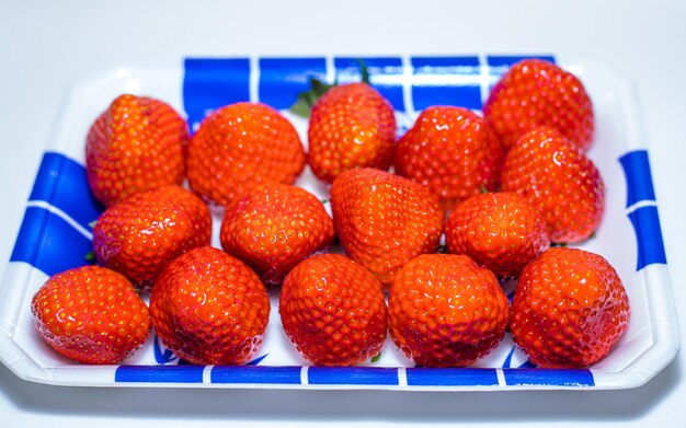 Erdbeeren auf einem weißen Teller auf einem weißen Tisch Selektiver Fokus