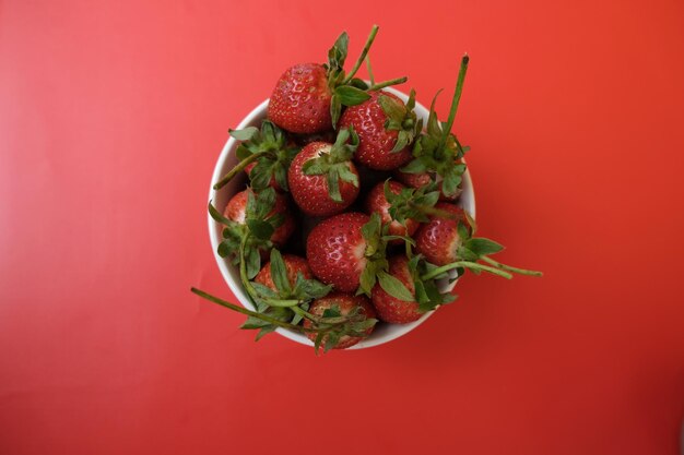 Erdbeeren im Teller und roter Hintergrund