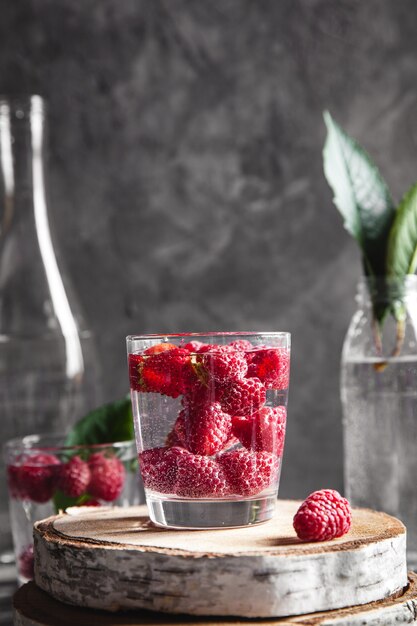 Erdbeeren im Wasser auf einem dunkelgrauen Hintergrund. Gesundes Essen, Obst. Ein Blumenstrauß als Dekoration