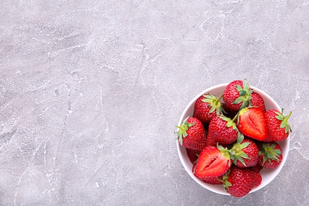 Erdbeeren in der Brülle auf grauem Beton