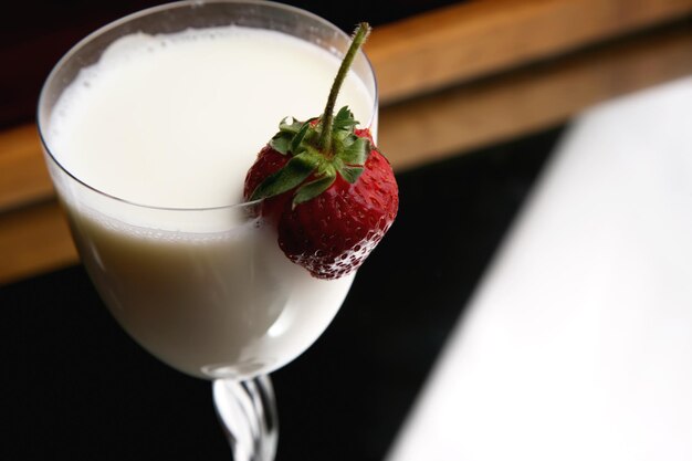 Erdbeeren in einem Glas mit Milch schneiden