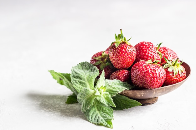 Erdbeeren in einer Holzschale mit Minze.