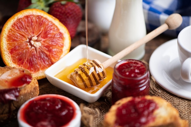 Erdbeeren mit Marmelade und Glas Milch. Naturfrühstück, rustikales Holz hautnah