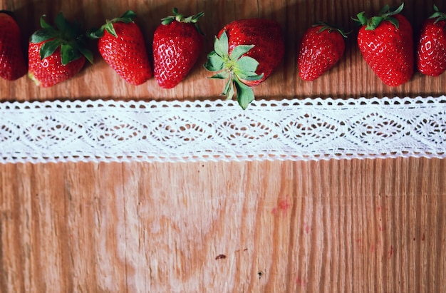 Erdbeeren oben auf Holz und Spitze