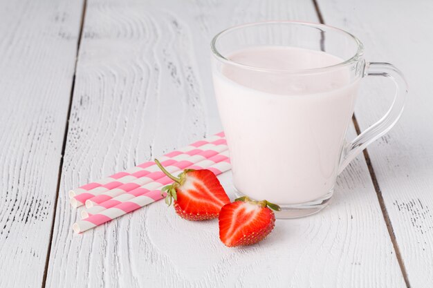 Erdbeeren und Milchgetränk auf weißem Holztisch