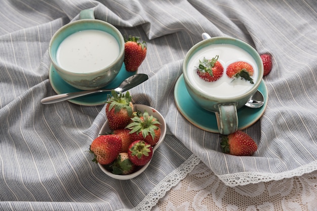 Erdbeeren und Milchgetränke auf Stoff.