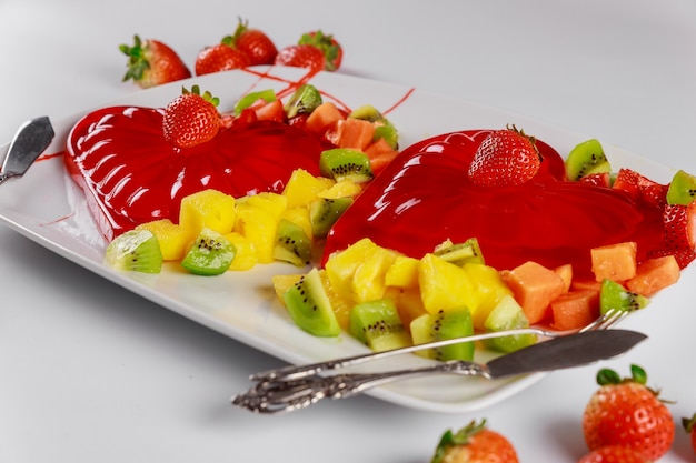 Erdbeergelatine dekoriert mit frischer Erdbeere, Kiwi und Ananas Dessert für Paare