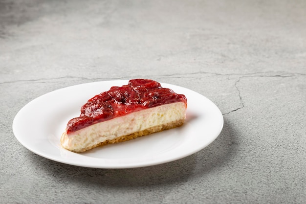 Erdbeerglasierter Käsekuchen auf weißem Geschirr auf dem Tisch