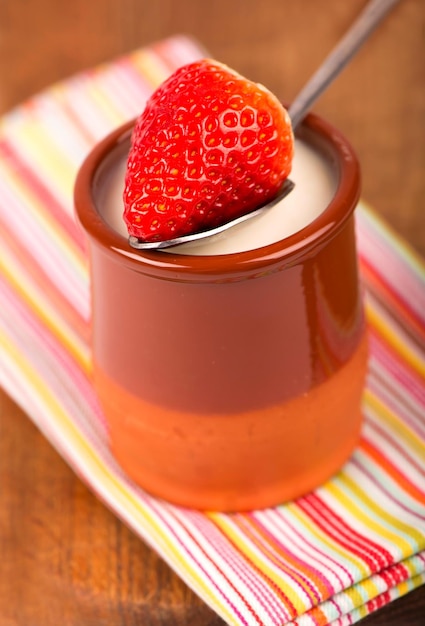 Erdbeerjoghurt mit frischen Erdbeeren auf Holzhintergrund