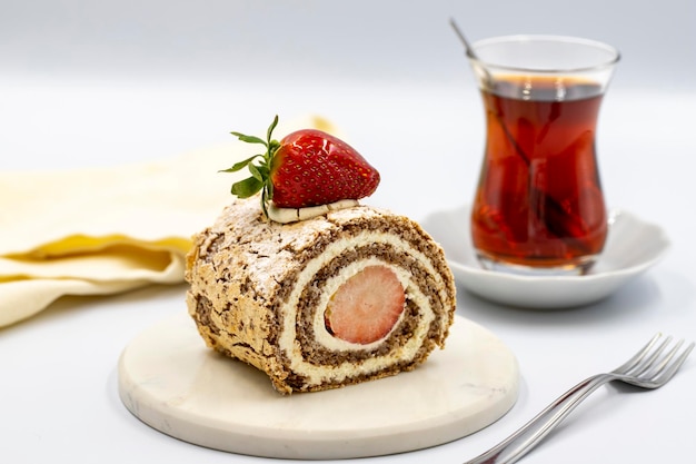 Erdbeerkuchen auf weißem Hintergrund Kuchen mit Milchcreme und Erdbeerfüllung zusammen mit einer Tasse Tee