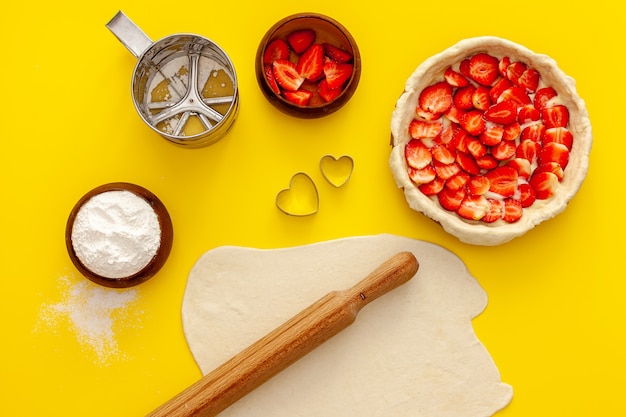 Erdbeerkuchen machen. Der Kuchen ist mit kleinen Herzen verziert