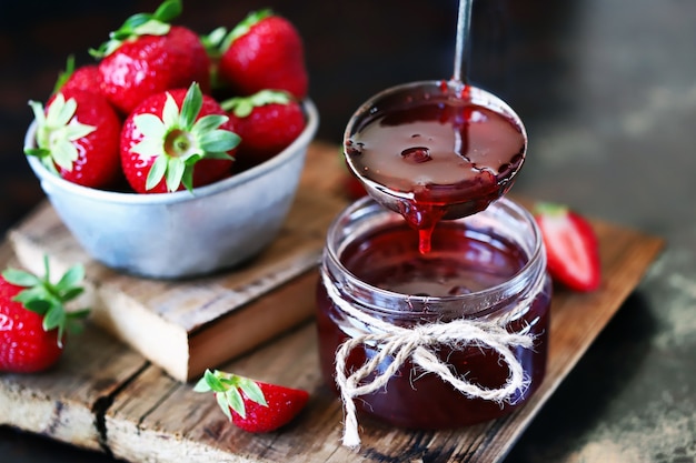 Erdbeermarmelade gießt in ein Glas.