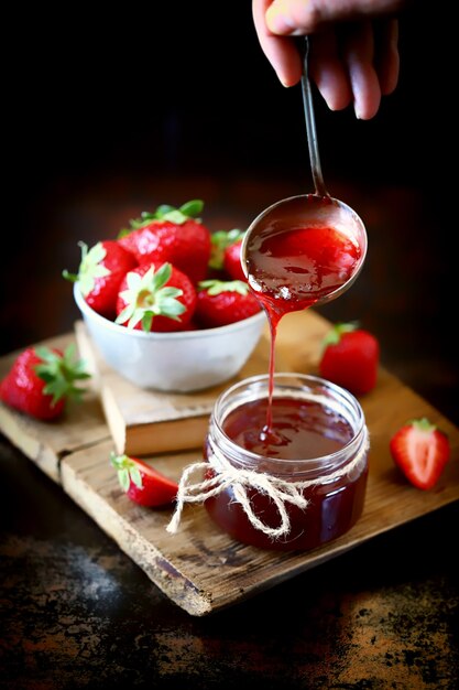 Erdbeermarmelade gießt in ein Glas.