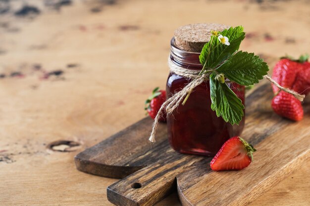 Foto erdbeermarmelade in einem glas auf einem holzbrett fermentierte beeren kopierraum