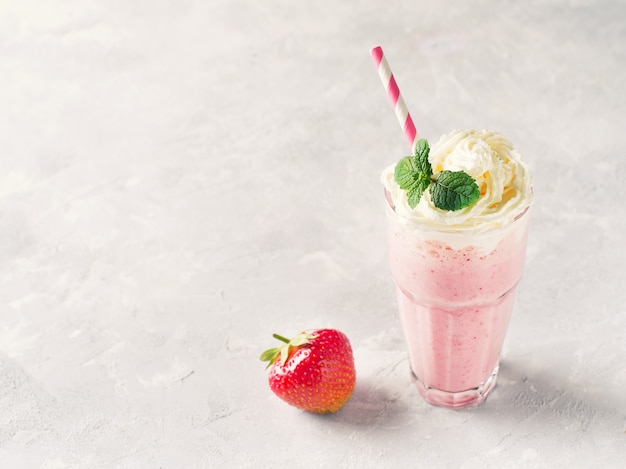 Erdbeermilchshake oder Smoothie und frische rohe Beeren auf Weiß