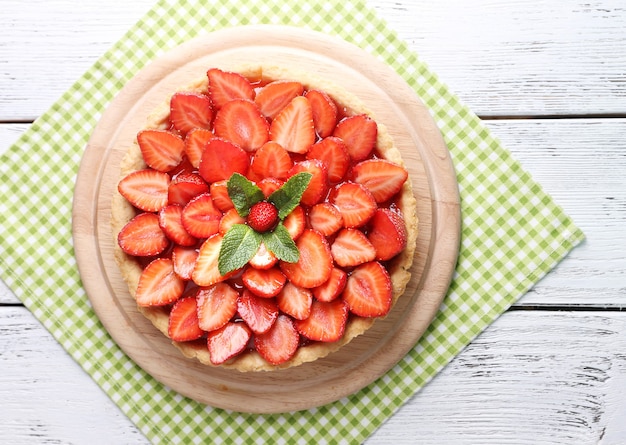 Erdbeertorte auf Holztablett, auf farbigem Holzraum