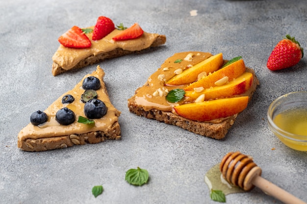 Erdnuss-Sandwiches Toast mit Honig, Minze, Blaubeere, Nektarine und Erdbeere