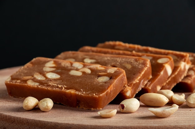 Erdnuss-Toffee auf einem Holzbrett. Scheiben östlicher Süßigkeiten mit Nüssen.