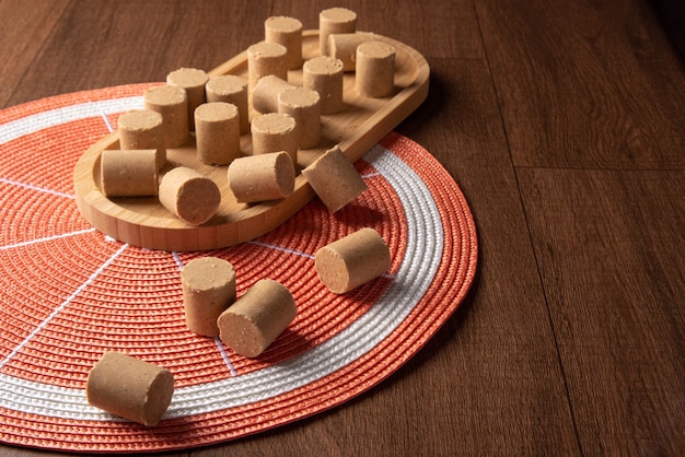 Erdnussbonbons (paçoca oder pacoca) Traditionelle brasilianische Süßigkeit auf Erdnüssenbasis, platziert auf einer runden orangefarbenen Tischdecke auf Holz. Selektiver Fokus.