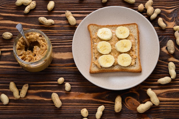 Erdnussbutter-Toast mit Bananenscheiben auf Holzhintergrund