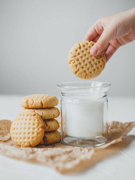 Erdnussbutterkekse mit Becher Milch auf Weiß