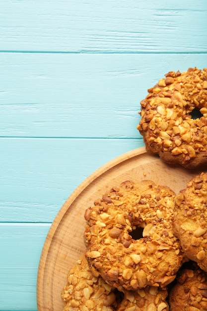 Erdnussplätzchen auf blauem Hintergrund aus Holz. Bäckereiprodukte. Vertikales Foto.