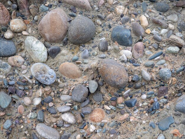 Erdschichten an einem Strand aus Kieselsteinen, Bodengeschnitten, Kopfsteinsteine und Erde nach dem Bagger, Bauarbeiten