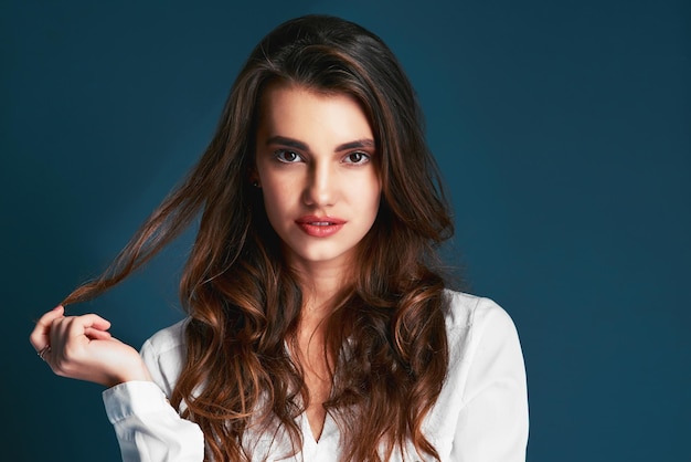 Eres hermosa y no lo olvides Foto de estudio de una atractiva joven mujer de moda posando sobre un fondo azul