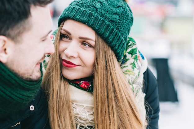 Eres mi amor. Pareja amorosa cariñosa en citas en Winter Park. Chica rubia mirando a su novio con cariño mientras está sentado en el banco