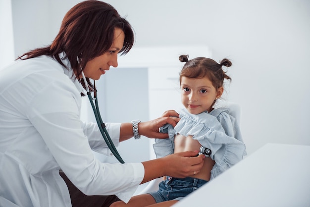 Erfahrene Kinderärztin arbeitet mit kleinen Mädchen in der Klinik.