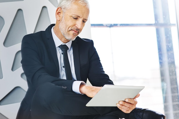 Erfolg hat für ihn immer Priorität Schnappschuss eines reifen Geschäftsmanns, der in einem Büro an einem digitalen Tablet arbeitet