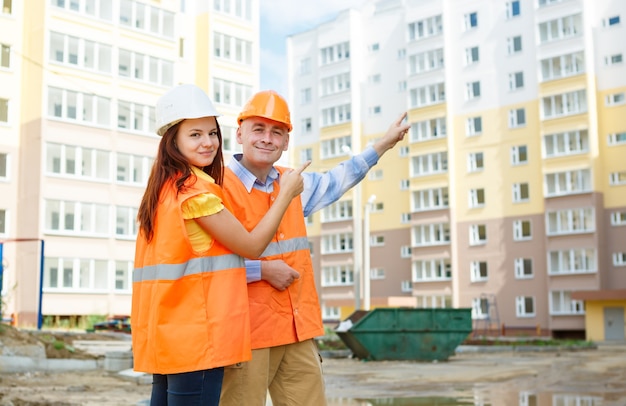 Erfolg weiblicher und männlicher Bauarbeiter gegen Häuser