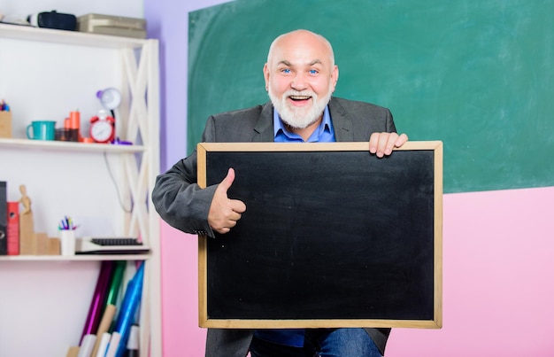 Erfolg zurück in die Schule Informationen zum Bildungskonzept finden Sie hier Prüfungs- und Abschlussergebnisse Platz für Kopierbereich Älterer Lehrer Mann hält Kreidetafel Senior-Lehrer mit leerer Tafel