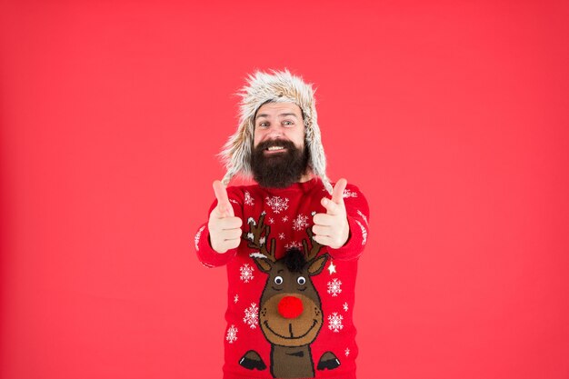 Foto erfolgreich sein. warme kleidung tragen. glücklicher hipster mit bart im lieblingspullover. strick- und pelzzubehör. neujahrsferien. frohe weihnachten. männliche wintermode. wohlfühlen bei jedem wetter.