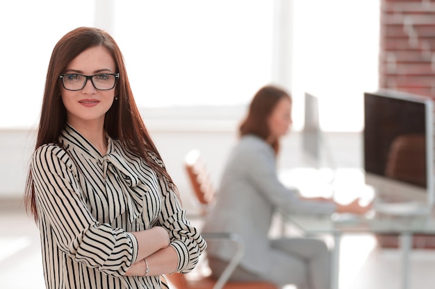Erfolgreiche Geschäftsfrau auf dem Hintergrund ihres Bürofotos mit Kopienraum