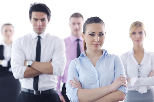 Erfolgreiche Geschäftsfrau, die mit ihren Mitarbeitern im Hintergrund in einem modernen, hellen Büro steht