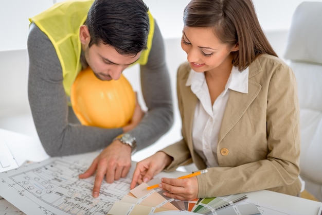 Erfolgreiche junge Architekten diskutieren über Baupläne und planen, was man besser machen könnte. Sie sind im Büro.