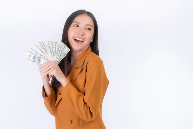 Erfolgreiche schöne asiatische Geschäftsfrau mit Geld, US-Dollar-Scheinen in der Hand, isoliert auf weißem Hintergrund mit Kopierraum Geschäftskonzept