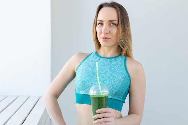 Erfolgreiche städtische Fitnessfrau, die Detox Smoothie empfiehlt