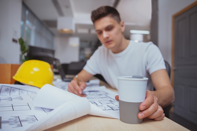 Erfolgreicher Architekt, der an Plänen im Büro arbeitet