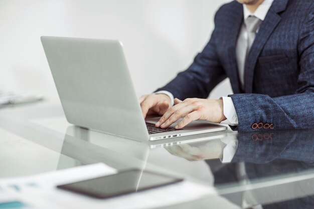 Erfolgreicher Geschäftsmann, der am Laptop am Arbeitsplatz arbeitet