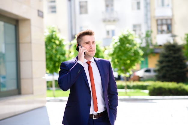 Erfolgreicher Geschäftsmann, der am Telefon und am Lächeln spricht.