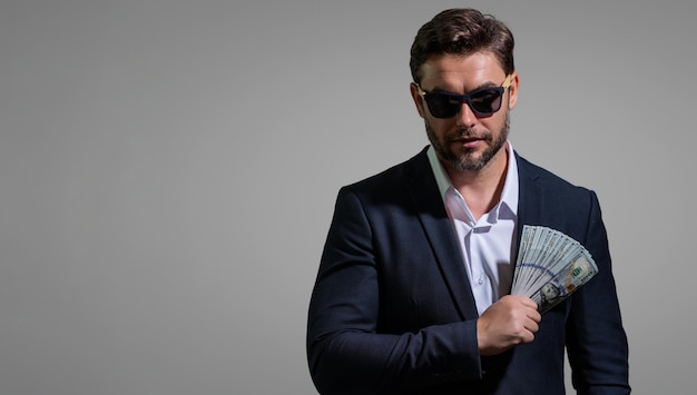 Erfolgreicher Geschäftsmann, der Geld zählt, hübscher Mann mittleren Alters, der einen Haufen Dollar-Banknoten hält.